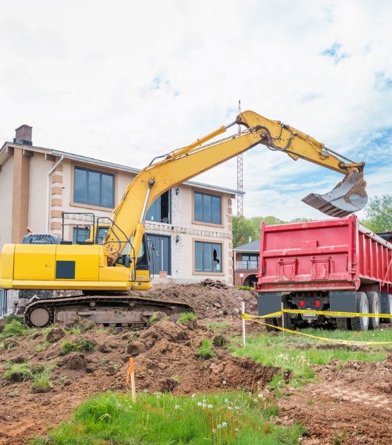 excavator-and-hauling-truck-during-house-construction-picture-id1201504349